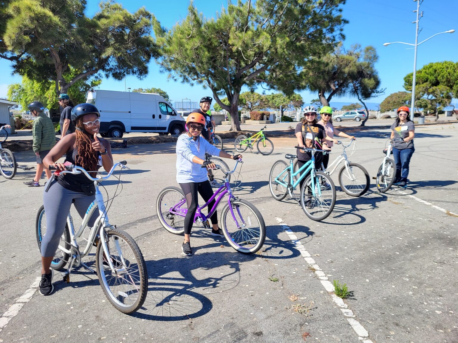 A group of Learn to Ride students smile as they sit on their bikes.