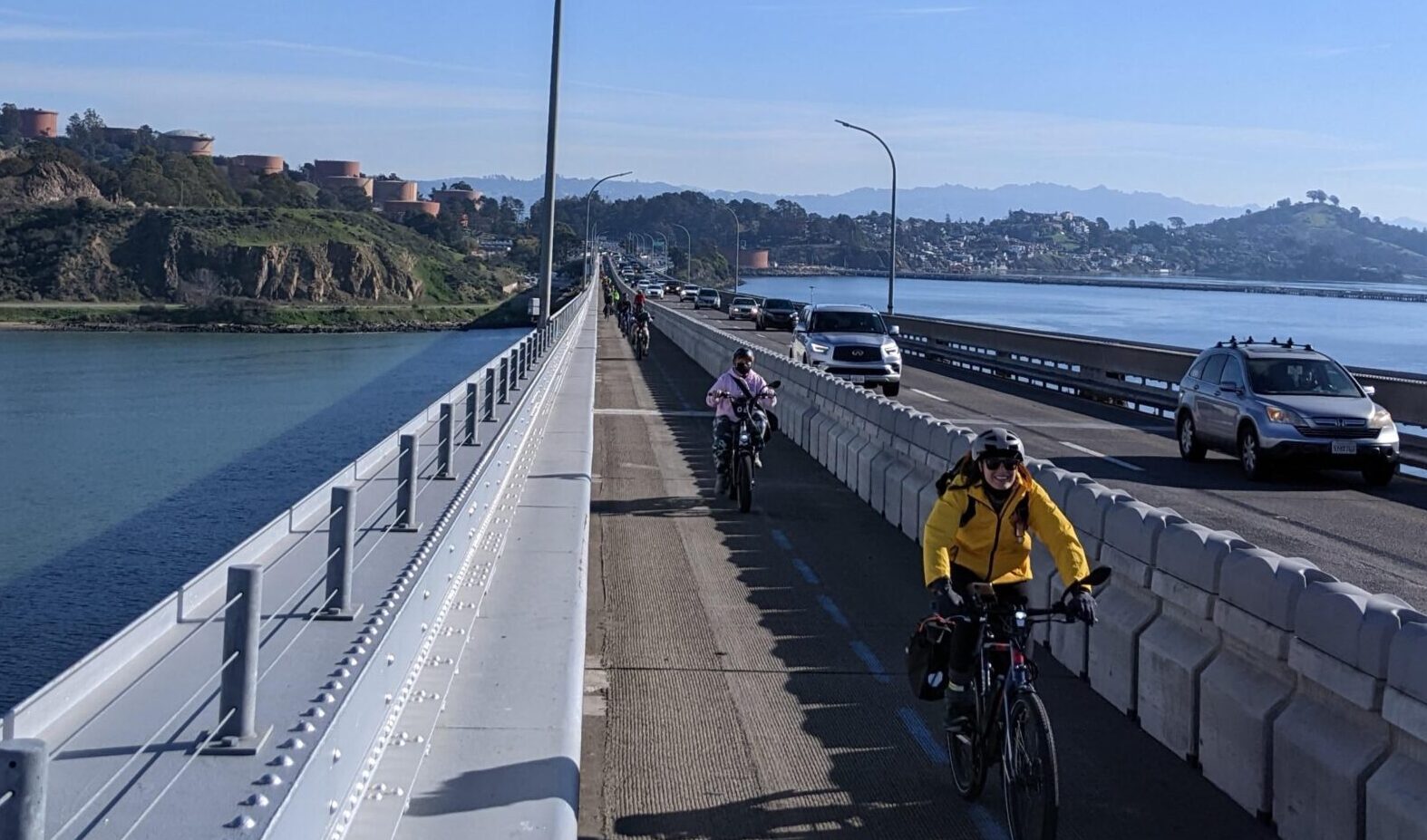 photo of people bicycling on the Richmond-San Rafael Bridge pathway and smiling