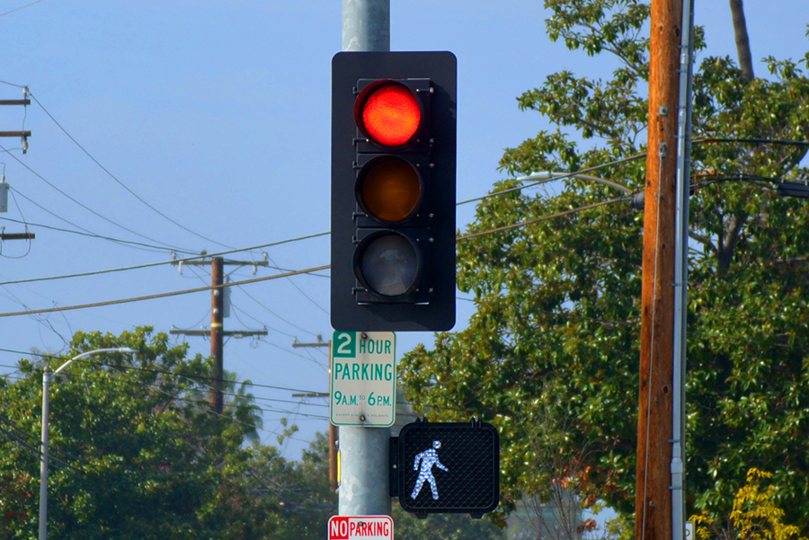 photo of a red traffic signal light above a white walk signal light