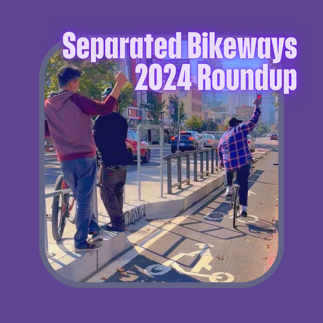 "Separated Bikeways 2024 Roundup" Photo of a person raising their fist in triumph while riding through a bikeway channel protected by a concrete bus stop island and railing - onlooker on the bus stop also raising their fist in solidarity