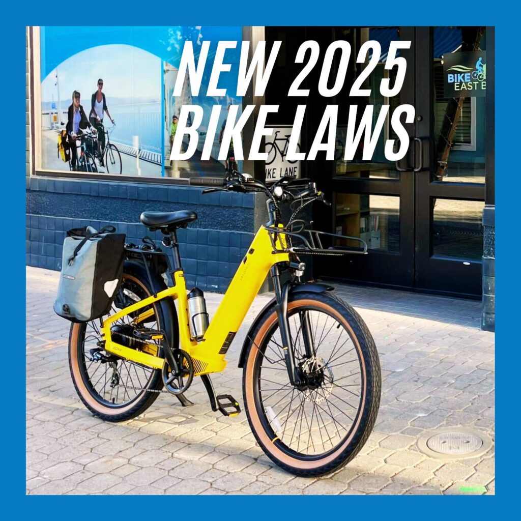 photo of a yellow electric bicycle with a front rack and side bags, parked in front of the Bike East Bay office