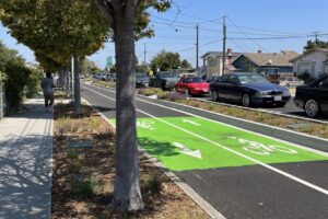 A photo of the completed Phase 1 of the Richmond Wellness Trail showing green painted bike lanes on Marina Way South
