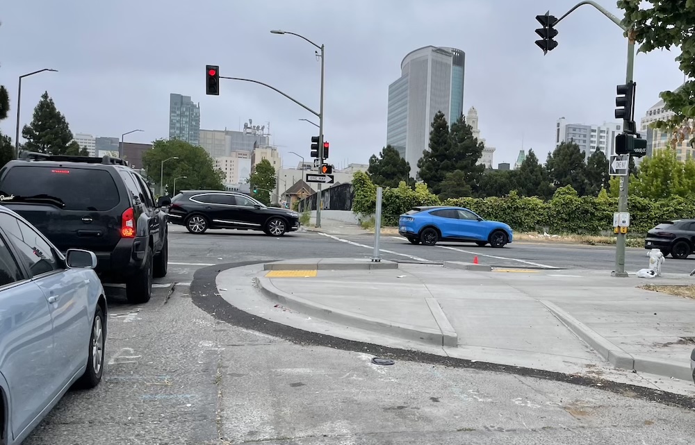photo of a sidewalk extension with a raised bicycle channel on 17th St at Brush in Oakland