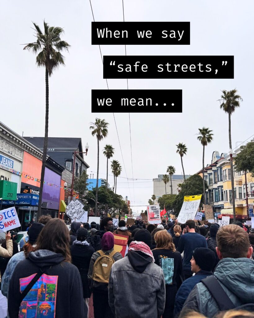 A large crowd of people peacefully protests down a Bay Area street