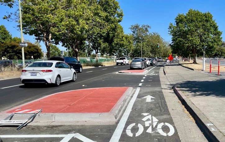 photo of a curbside protected bikeway on 7th Street by Laney College in Oakland, with several concrete islands between the bike lane and car traffic