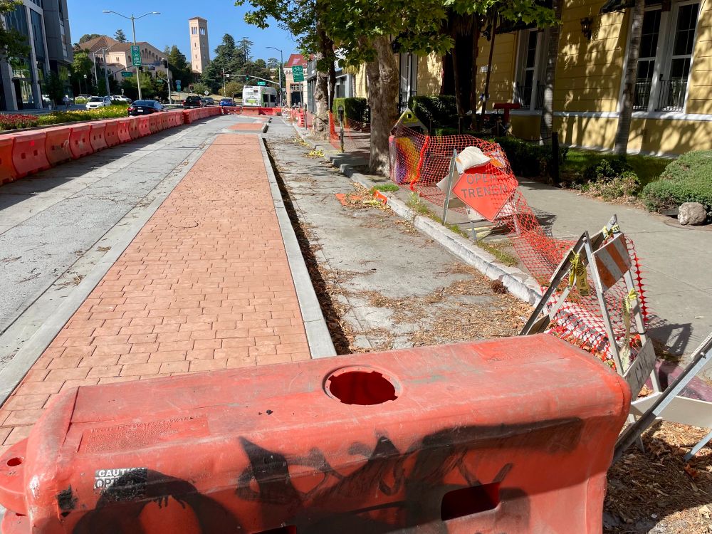 photo of a curbside protected bikeway under construction on Harrison Street north of Grand Ave in Downtown Oakland