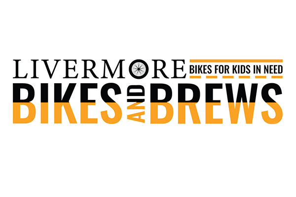 The image shows the logo for an event called Livermore Bikes and Brews. The text is arranged in three lines: The top line says LIVERMORE in black, with a small graphic of a bicycle wheel replacing the 'O' in Livermore. To the right of that, in a smaller font, is BIKES FOR KIDS IN NEED in black with an orange line above and below the text. The second line has BIKES in large, bold orange text. The third line has the words AND BREWS, with AND in smaller, black text and BREWS in large, bold orange text. The overall impression is a charity cycling and beer-related event benefitting children.