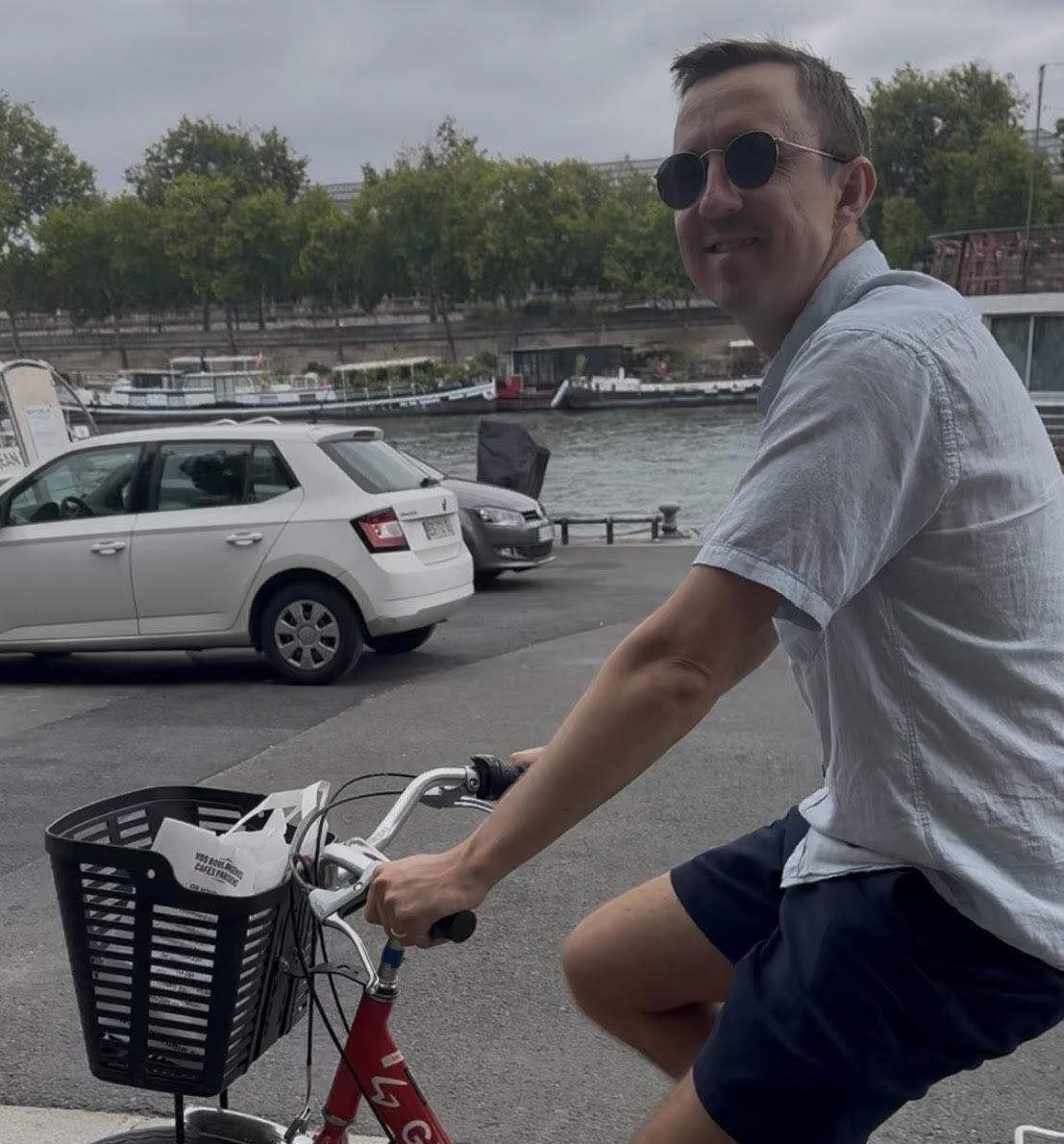 Ben smiles and rides a red bicycle
