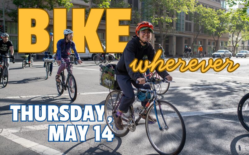 A vibrant promotional banner for "Bike Wherever" day on Thursday, May 14 featuring a diverse group of cyclists riding through a sunny city intersection. Large, bold text overlays the scene.
