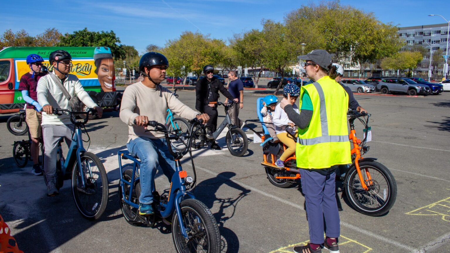 A group of people riding e-bikes wait at the start of a test track.