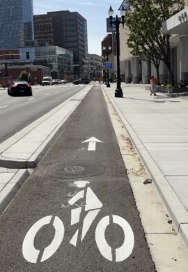 Photo of a curb protected bikeway on an urban street in Downtown Oakland